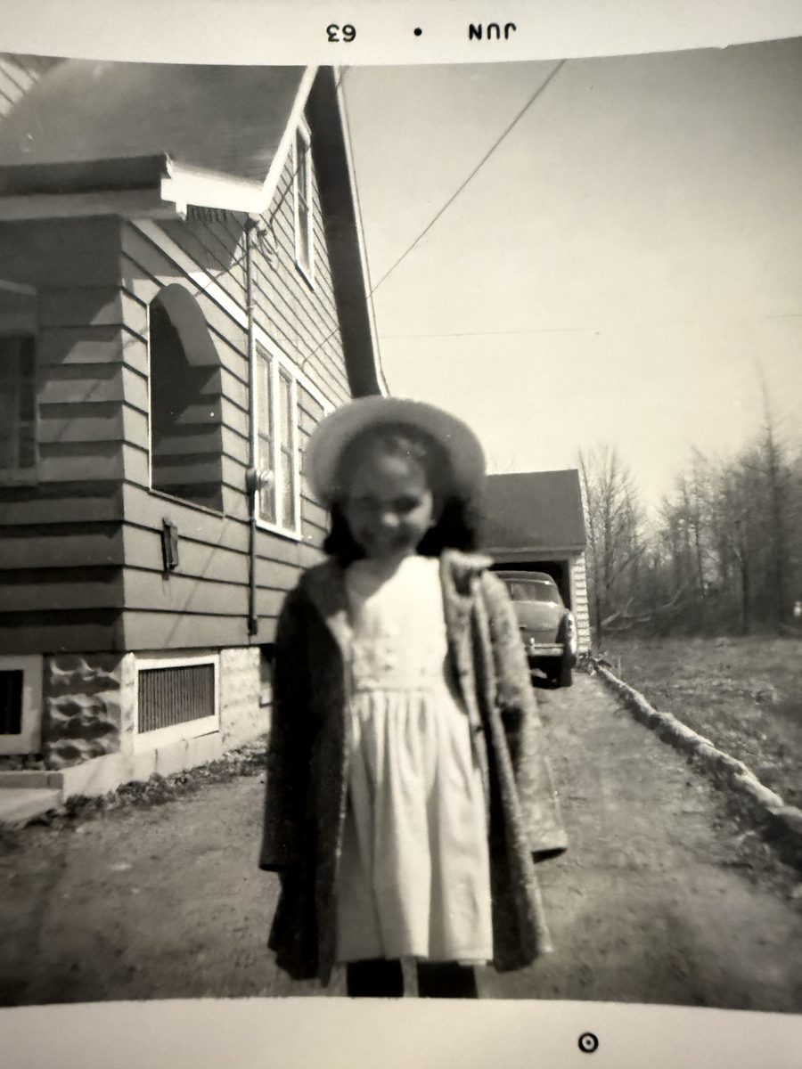 Melanie as a young girl in a white dress and hat, June 1963